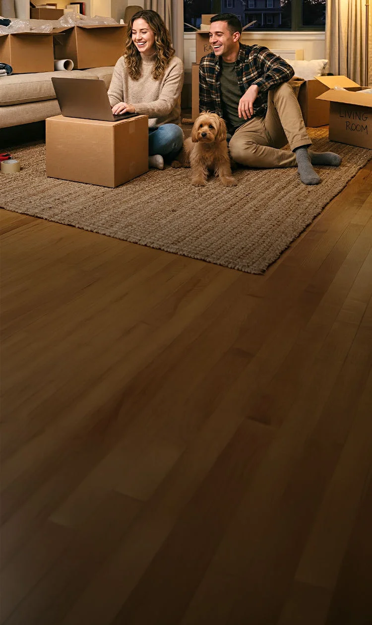 Couple with dog surrounded by moving boxes in new home transferring Optimum Fiber Internet
