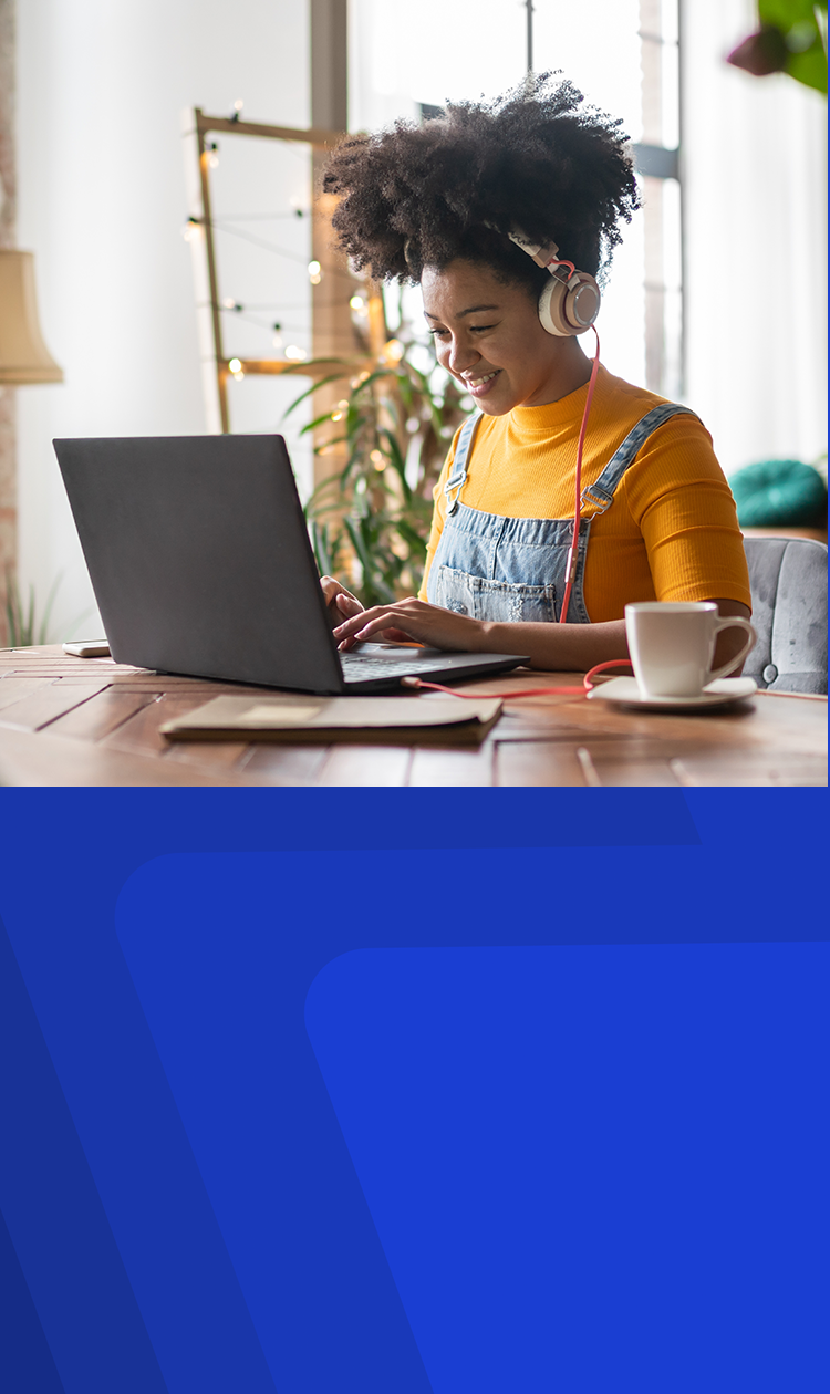 A young woman having a cup of coffee while on her laptop listening to either music or streaming a movie with her headphones on while surfing the Internet using Optimum Fiber Internet.