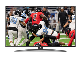 Flat-screen TV on a stand showing an American football game with players on a green field 