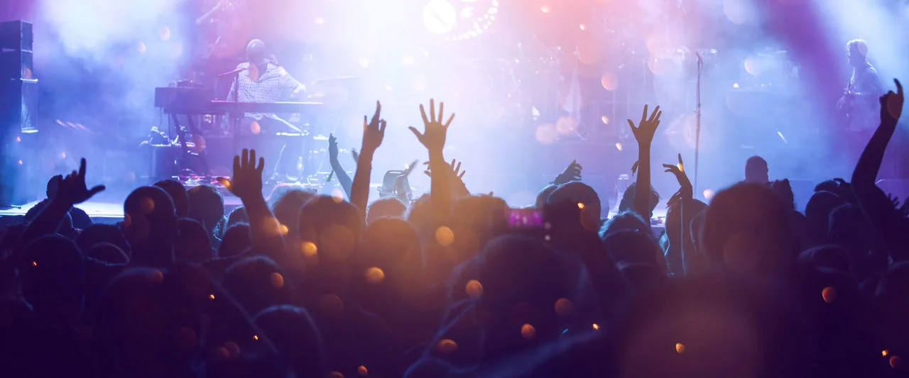 Público en un concierto con las manos en alto