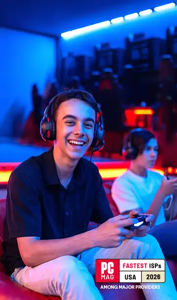 Smiling teen gamer in headset holding a controller in a neon-lit room; PCMag Fastest ISPs USA 2026 badge lower right