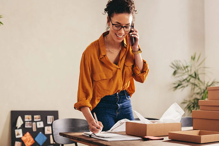 Woman speaking on phone at her desk.
