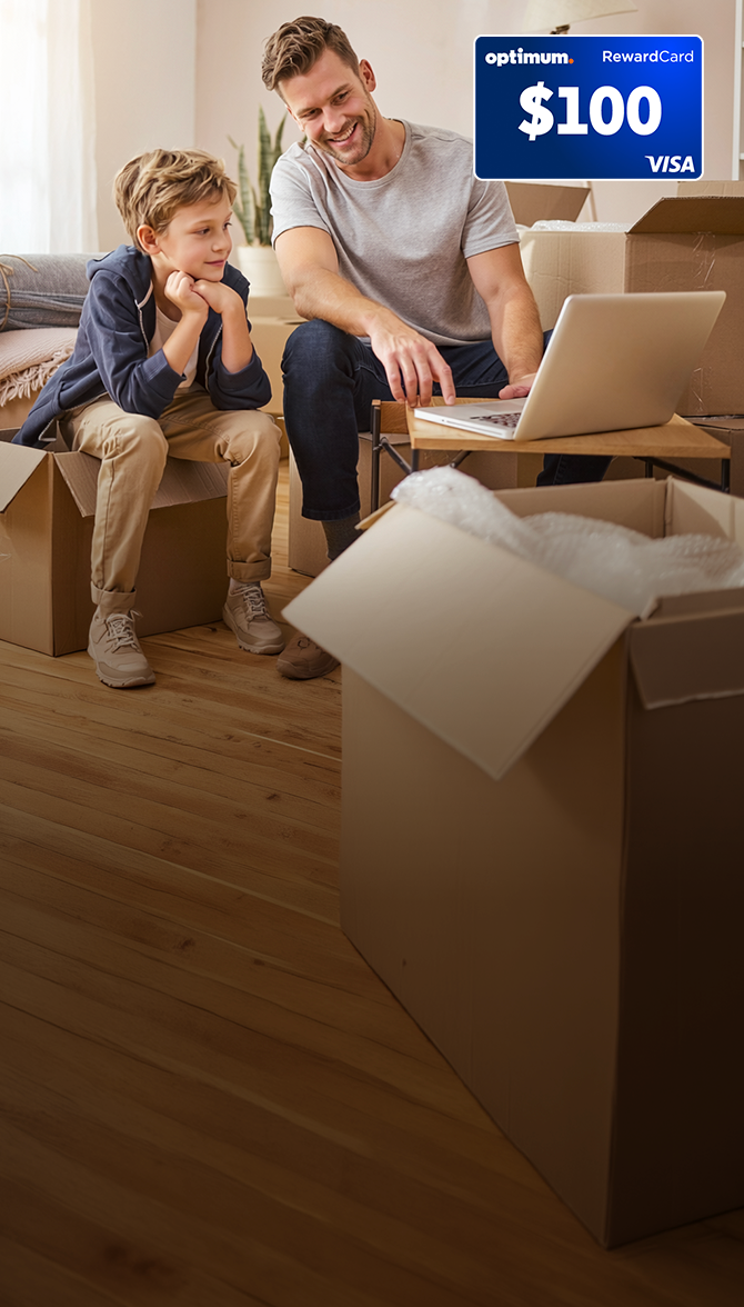 Father and son setting up laptop in new home after transferring Optimum Internet service
