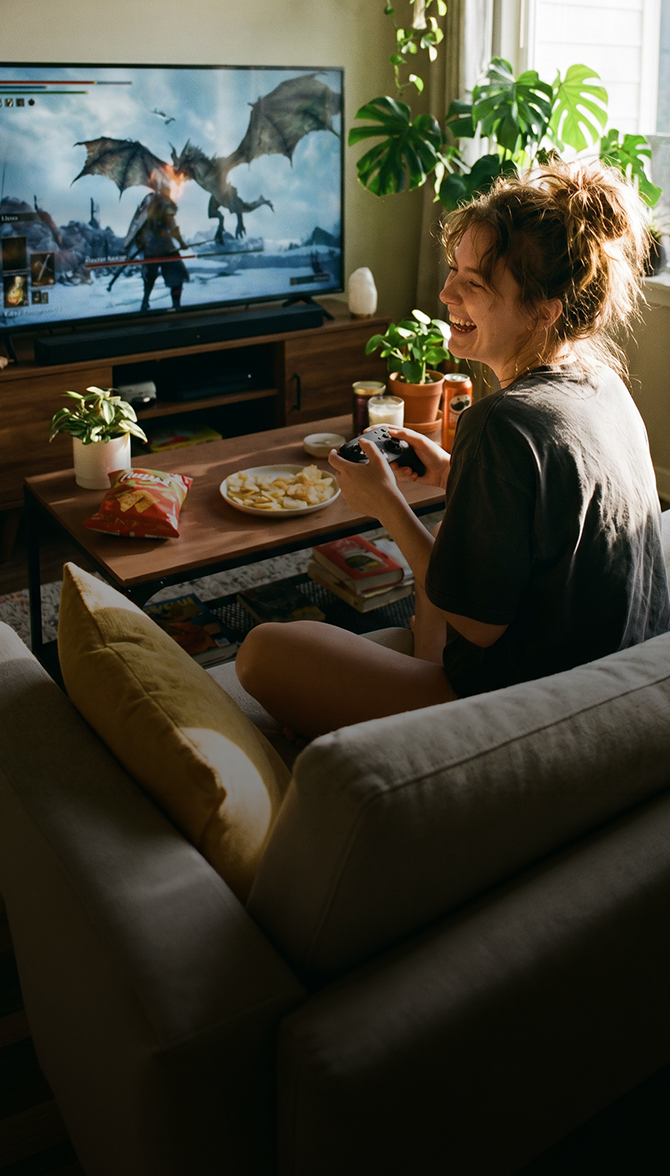 Woman on couch with laptop using 300 Mbps Optimum Fiber Internet