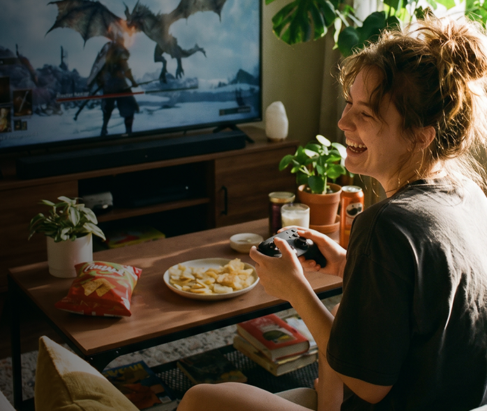 Woman on couch with laptop using 300 Mbps Optimum Fiber Internet