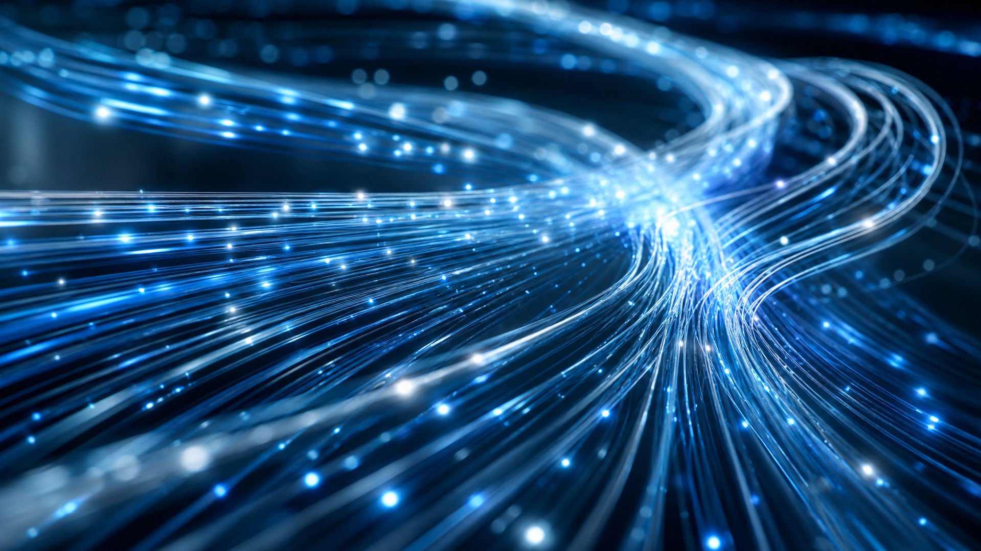 Glowing bundle of blue fiber optic cables transmitting bright light particles, representing Optimum high-speed fiber internet.