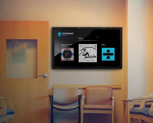 Image of a waiting room featuring a TV display showcasing Stingray Music content.