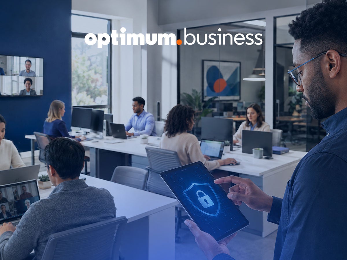 Office employee holds a tablet showing a security lock icon, representing Optimum Business network security protecting the workplace.
