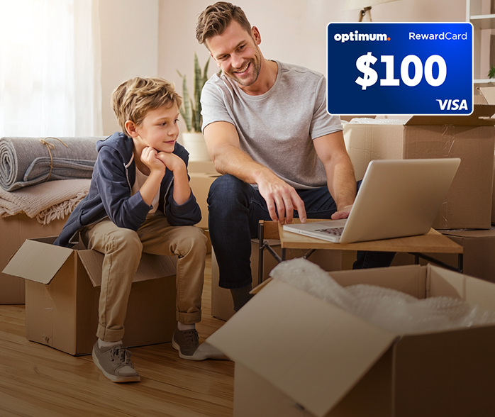 Father and son setting up laptop in new home after transferring Optimum Internet service