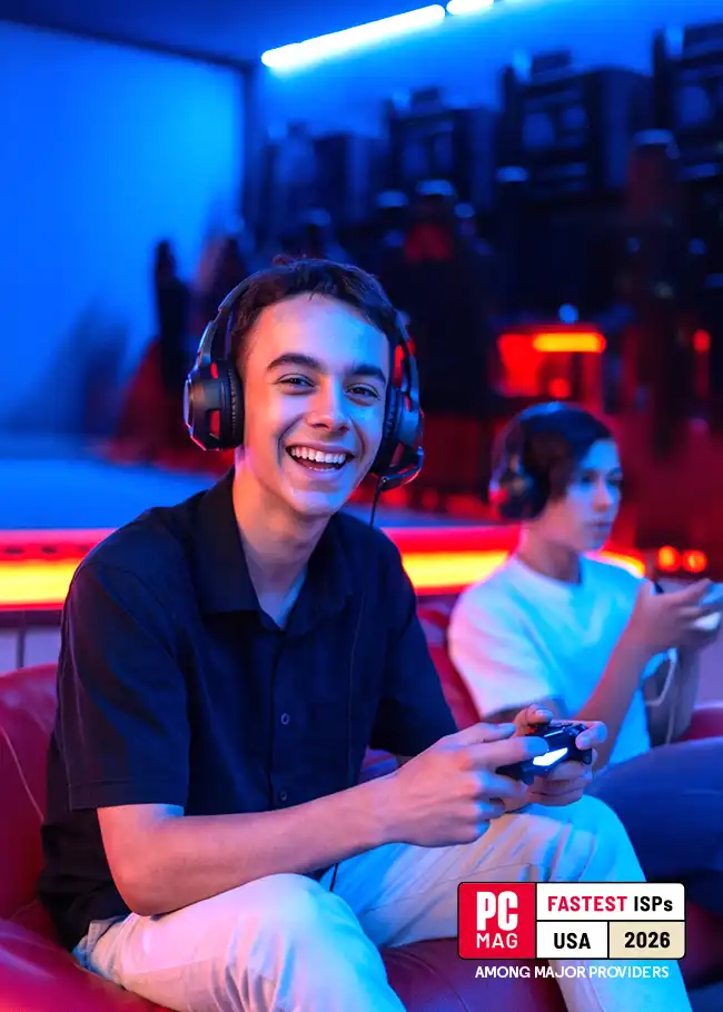 Smiling teen gamer in headset holding a controller in a neon-lit room; PCMag Fastest ISPs USA 2026 badge lower right