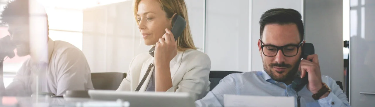 Empleados de oficina hablando por teléfono durante una reunión
