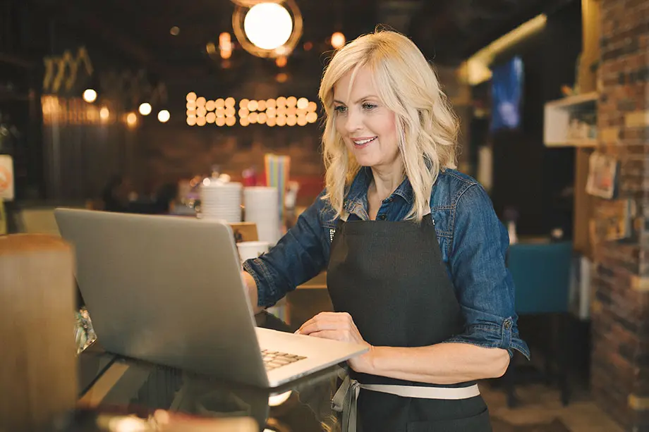 Woman working on laptop in a cafe.