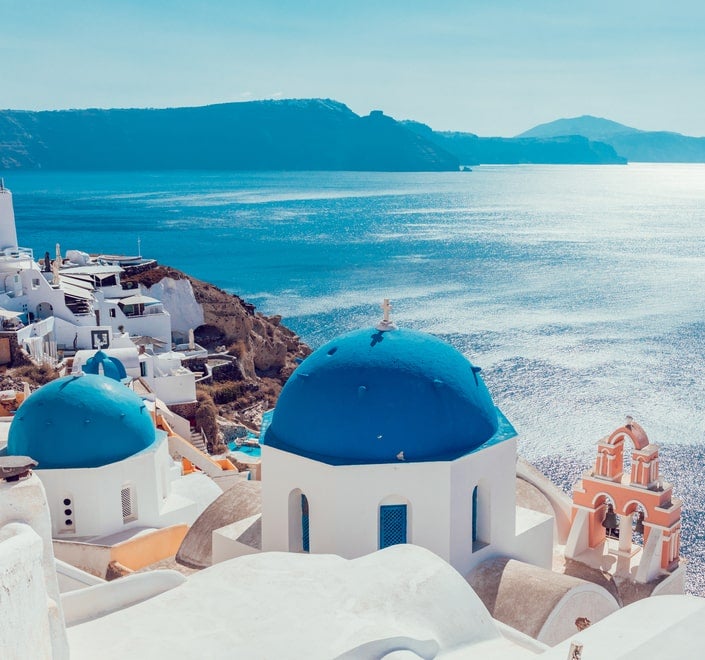 Tarjeta de un canal de televisión con una imagen que muestra los característicos edificios blancos con cúpulas azules de Santorini, comúnmente asociados con la arquitectura tradicional griega.