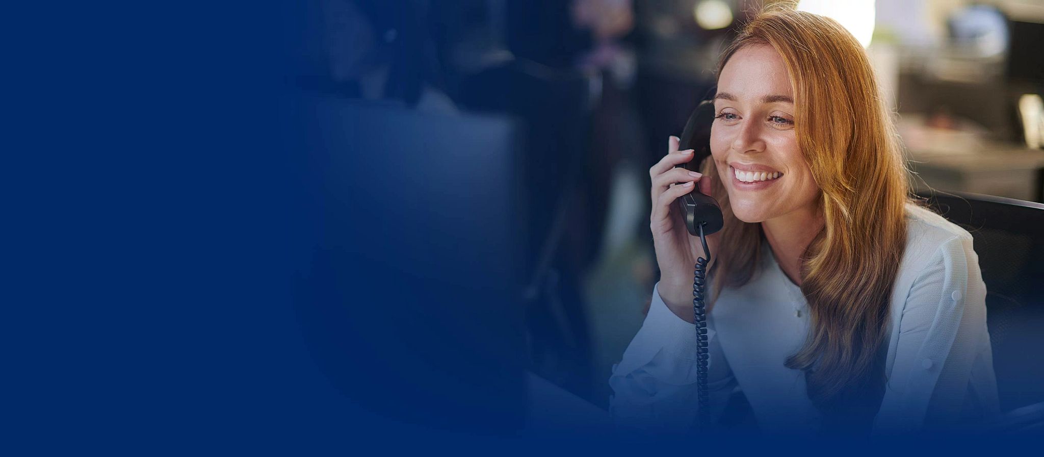 una mujer habla por teléfono en la oficina