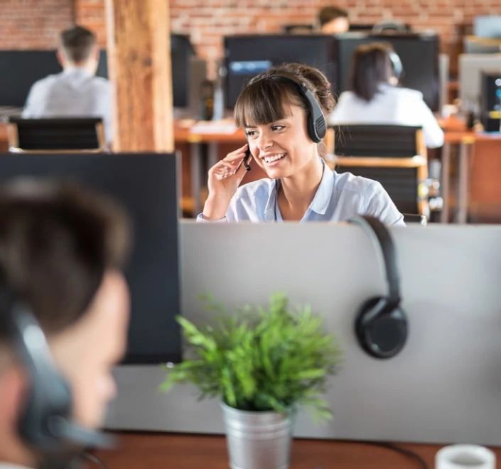 Agente de un centro de atención telefónica sentado en su escritorio con auriculares
