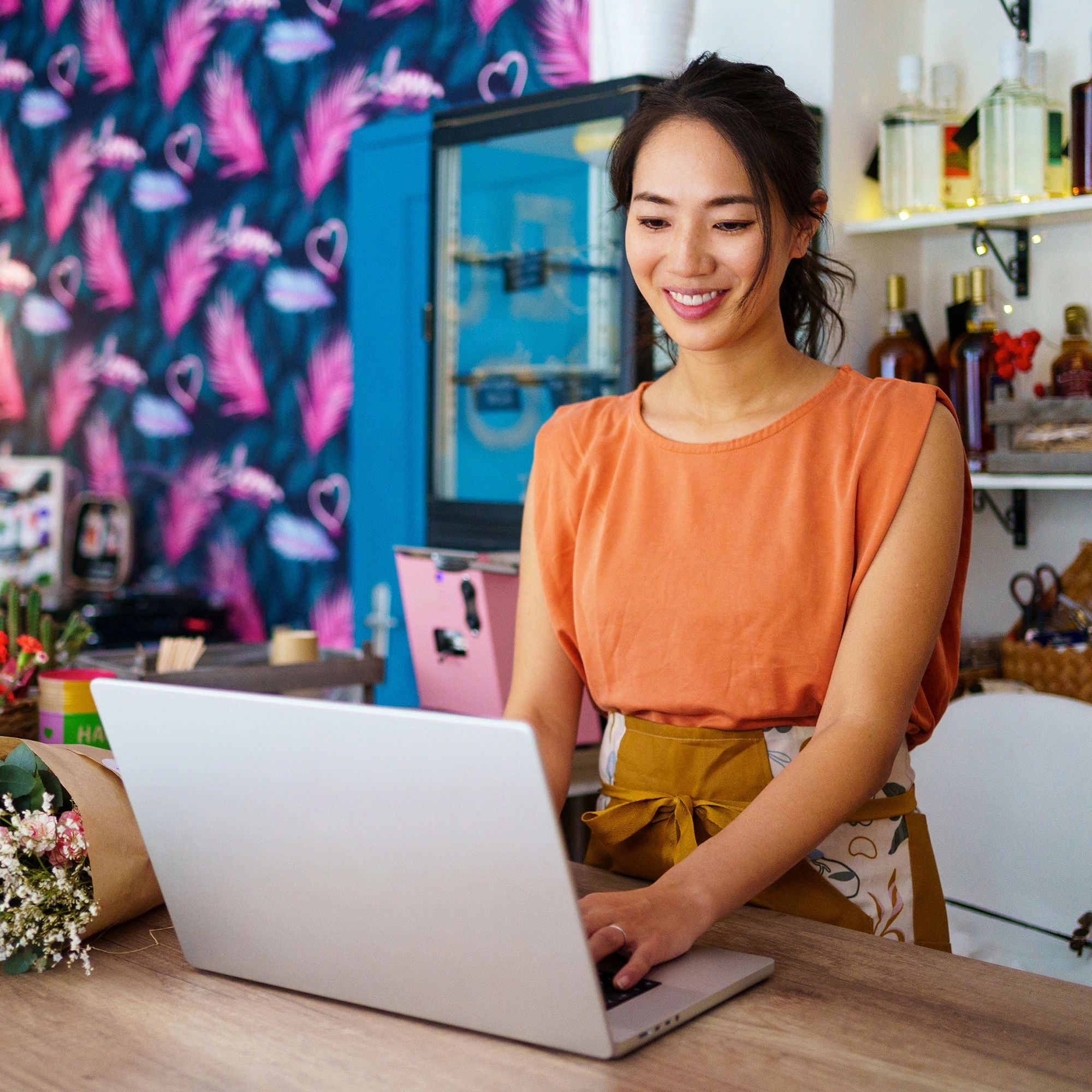 Woman in a workshop studio analyzing data on a laptop, demonstrating proactive business protection and cloud-based security.