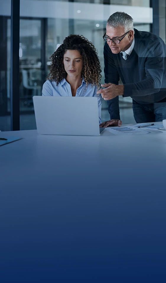 IT professionals and business team collaborating at a laptop, reviewing Secure Internet Plus cyber protection settings.
