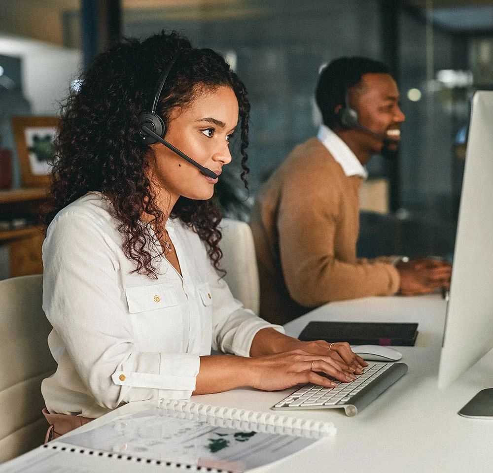 Dos agentes de atención telefónica trabajando uno al lado del otro