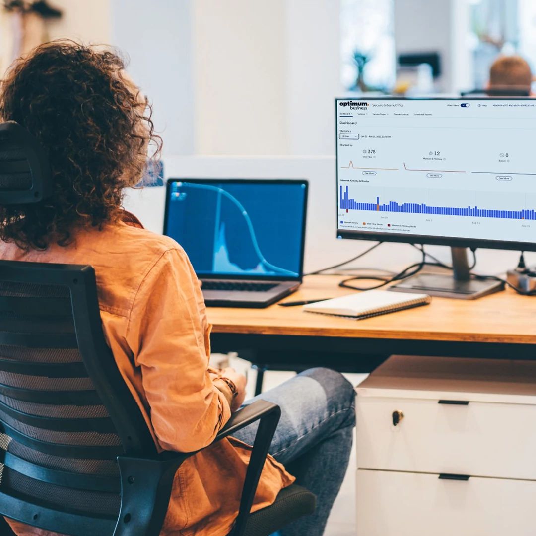 Overhead view of an analyst reviewing network data charts on a computer screen.
