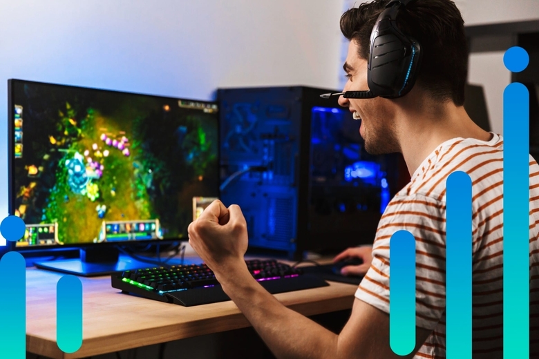 A young man sitting at a home PC gaming setup pumps his fist in victory, with Optimum blue graphic overlay